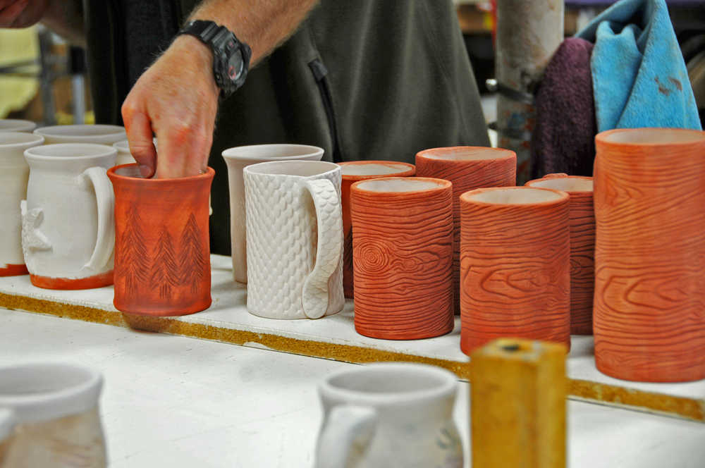 Photo by Elizabeth Earl/Peninsula Clarion Bryan Olds of Kenai prepares his pottery mugs to be fired in the kiln at the Fine Arts Building in Kenai on Friday, April 15, 2016. The pottery studio, the only cooperative one in the state, has been operating for about 42 years.