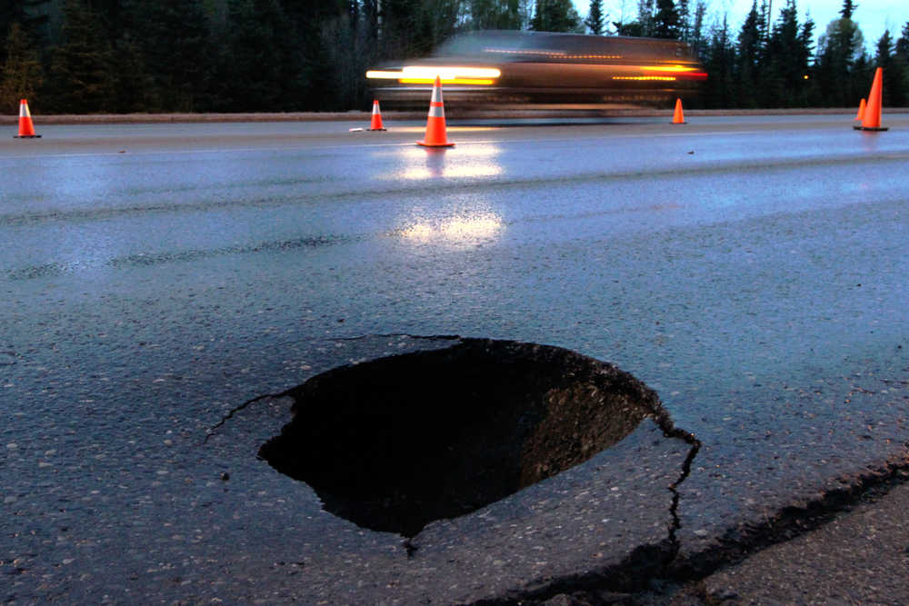 A sinkhole opens the pavement of the Kenai Spur Highway near Forest Drive on Tuesday, April 26 in Kenai. The Alaska Department of transportation blocked off two lanes of the four-lane road due to the extensive cavern beneath the hole.