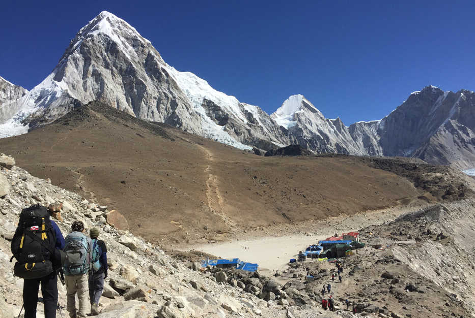 This April 10, 2016 photo shows trekkers heading to Everest Base Camp, Nepal. The cone-shaped Pumo Ri peak (23,495 feet (7,161 meters) is seen in the background. A trek to Everest Base Camp along mountain paths that hug deep gorges offers renewal and a test of mental and physical limits. Along the way there are sore knees and altitude sickness, but the spectacular landscapes, friendly villagers and moments of tranquility make the journey an unforgettable experience. (AP Photo/Karin Laub)