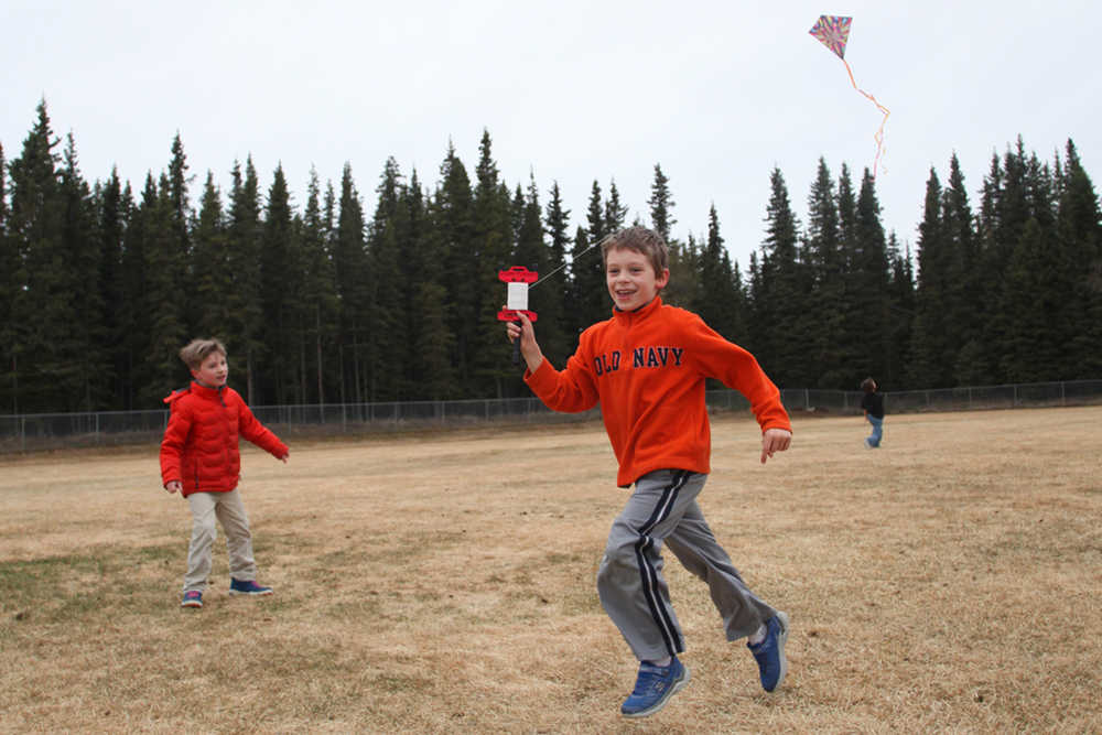 Photo by Kelly Sullivan/ Peninsula Clarion Kelly Brewer's first grade student, Blaze Cassidy, races through the football field to keep his kite flying Thursday, April 28, 2016, at Kalifornsky Beach Elementary, in Soldotna, Alaska. Cassidy and his classmates were using the exercise to learn about the power of wind.