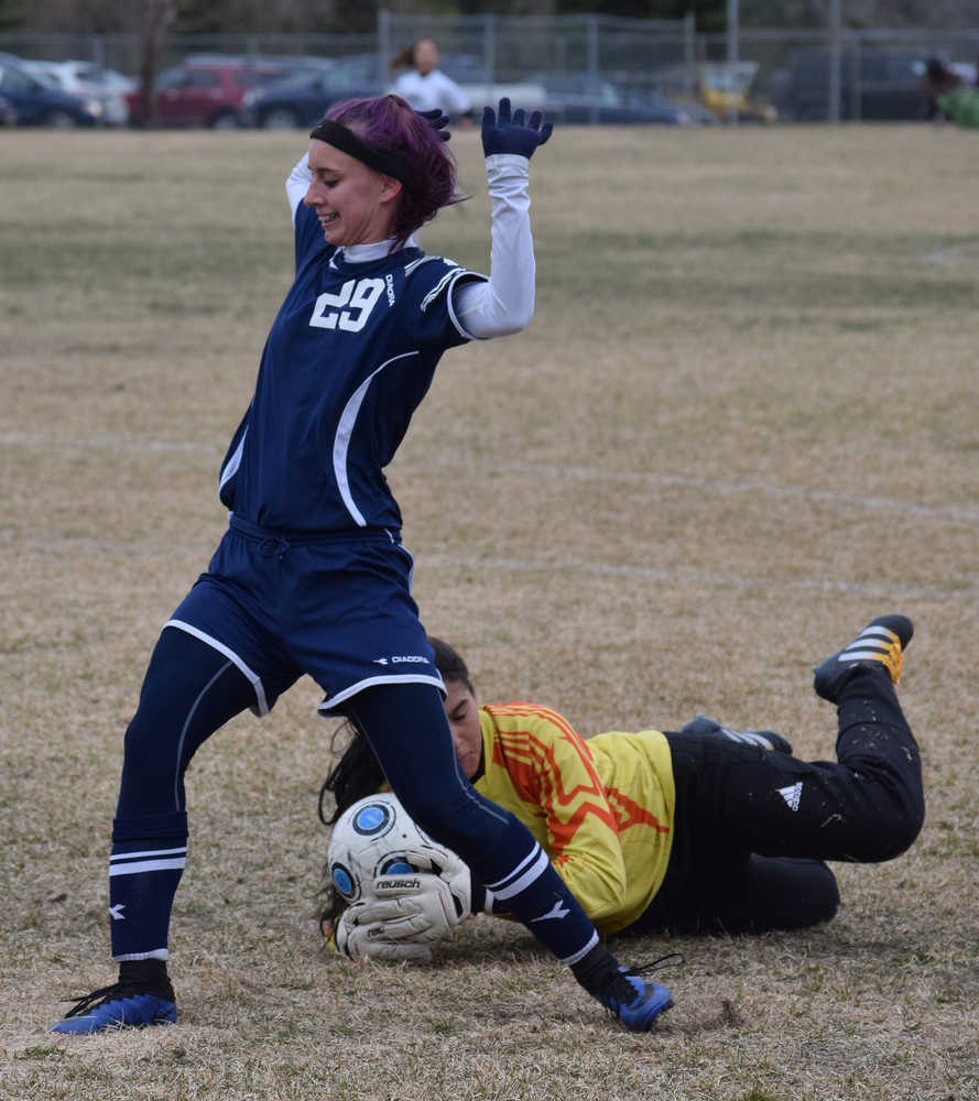 Photo by Joey Klecka/Peninsula Clarion Nikiski goaltender Brianna Vollertsen snatches the ball away just ahead of Soldotna attacker Abi Tuttle Saturday at Nikiski High School. The Stars beat the Bulldogs 3-0.