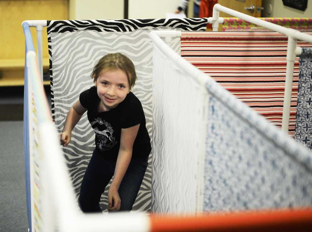 Brynnen Hanson runs through a maze of cloth panels at AK Kids Early Learning Center on Saturday, April 30 in Kenai.
