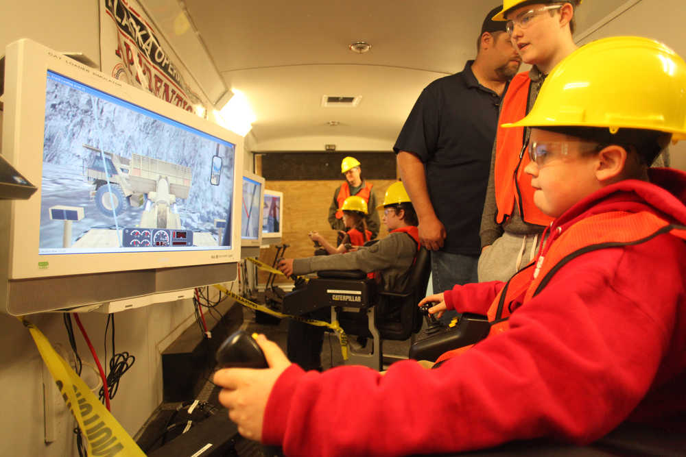 Photo by Kelly Sullivan/ Peninsula Clarion Kenai Middle School student Jaiden Burdick tries out a construction simulator during Alaska Construction Career Days Friday, April 28, 2016 at the Soldotna Regional Sports Complex.