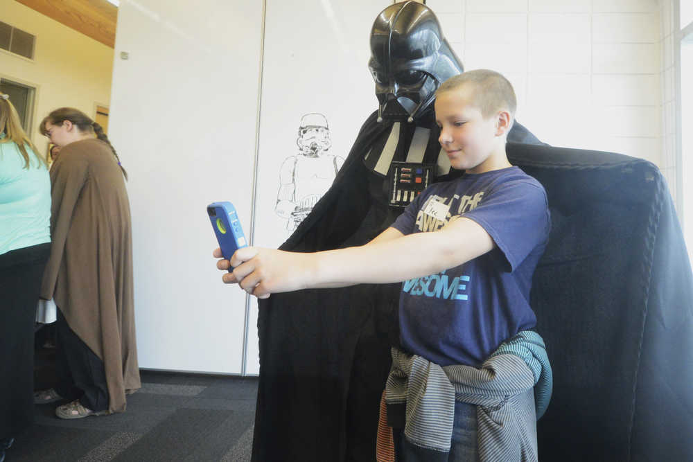 Photo by Megan Pacer/Peninsula Clarion Lee Leadens, 11, takes a selfie with James Adox, a children's librarian dressed as Darth Vader from "Star Wars," during an event called May the Fourth be With You on Wednesday, May 4, 2016 at the Kenai Community Library in Kenai, Alaska. Dozens of area kids swarmed the library during the event's inaugural year, said Ryanna Thurman, library assistant for information technology.