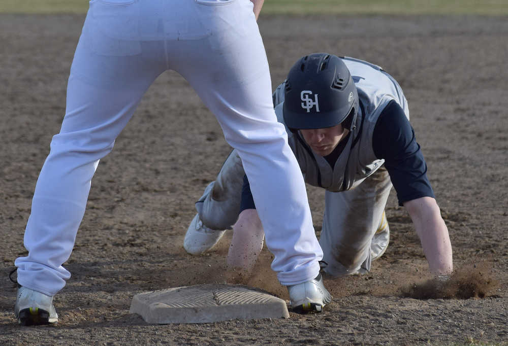 Photo by Joey Klecka/Peninsula Clarion Soldotna's Joey Becher dives for first base just before Kenai Central first baseman XXX catches the ball Wednesday at the Kenai Little League fields.