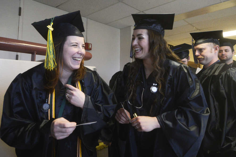 Photo by Megan Pacer/Peninsula Clarion Soldotna residents Cassandra Boze, left, and Becca Satathite share a laugh just before their graduation ceremony on Thursday, May 5, 2016 in the Renee C. Henderson Auditorium at Kenai Central High School in Kenai, Alaska. Boze graduated with a Associate Degree of Appied Science in Nursing, and Satathite with an Associate Degree of Applied Science in Paramedic Technology.