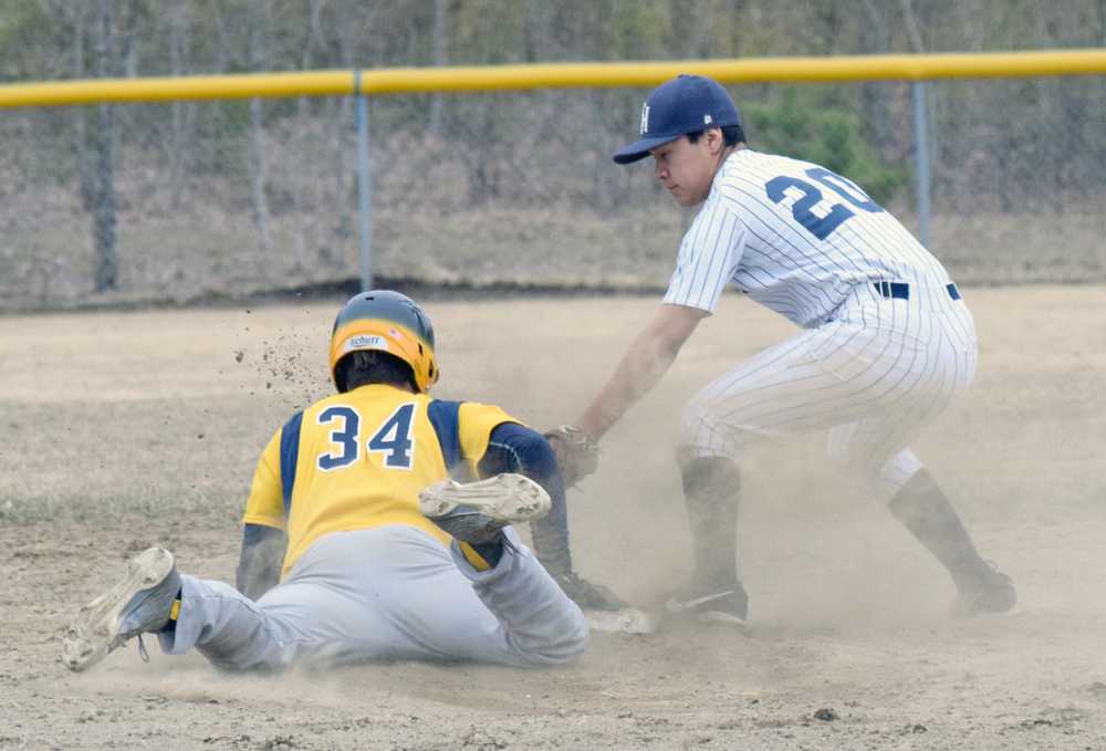 Photo by Jeff Helminiak/Peninsula Clarion Homer's Michael Swoboda beats out a double in front of the tag of Soldotna second baseman Terrance Slats on Thursday at the Soldotna Little League fields.