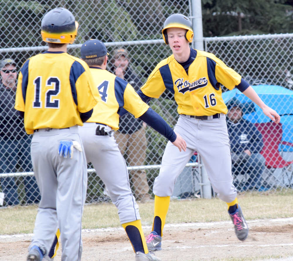 Photo by Jeff Helminiak/Peninsula Clarion Homer's Garrett Butcher celebrates a home run with Michael Swoboda in front of Joe Ravin (12) on Thursday in a game against Soldotna at the Soldotna Little League fields.
