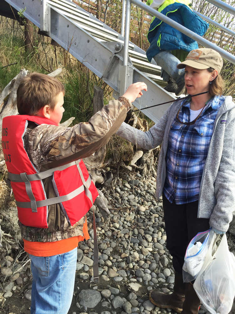Photo by Megan Pacer/Peninsula Clarion Chris Bessette, a third grader from Soldotna Elementary, shows off the trash he found to Soldotna Elementary teacher Shaya Straw during this year's Kenai River Spring Cleanup event on Friday, May 6, 2016 at Soldotna Creek Park in Soldotna, Alaska. More than 600 kids combed the riverbanks in several locations on the central Kenai Peninsula, competing for prizes and learning about good stewardship.