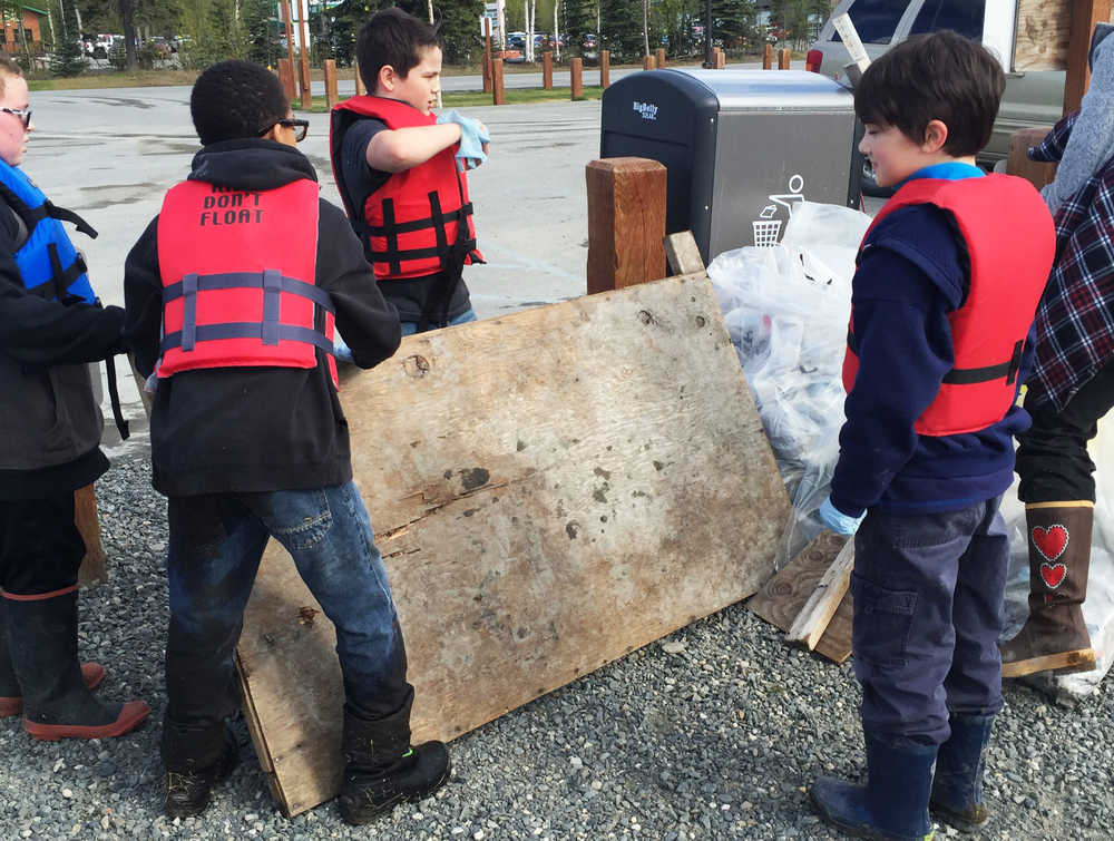 Photo by Megan Pacer/Peninsula Clarion Students from Soldotna Elementary, add a large board of wood to a pile of trash during this year's Kenai River Spring Cleanup event on Friday, May 6, 2016 at Soldotna Creek Park in Soldotna, Alaska. More than 600 kids combed the riverbanks in several locations on the central Kenai Peninsula, competing for prizes and learning about good stewardship.