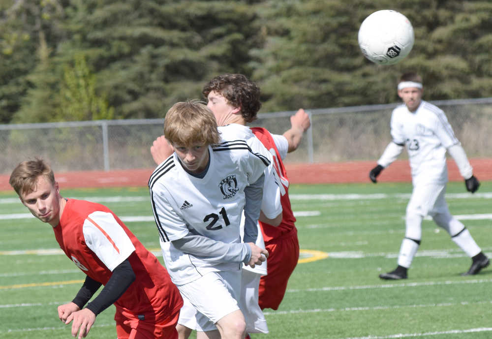 Photo by Jeff Helminiak/Peninsula Clarion Sandwiched between Wasilla's Tim Voloshin (8) and Kevin Harper (10), Kenai Central's Riley McKee gets a head on the ball Friday at Kenai Central High School.