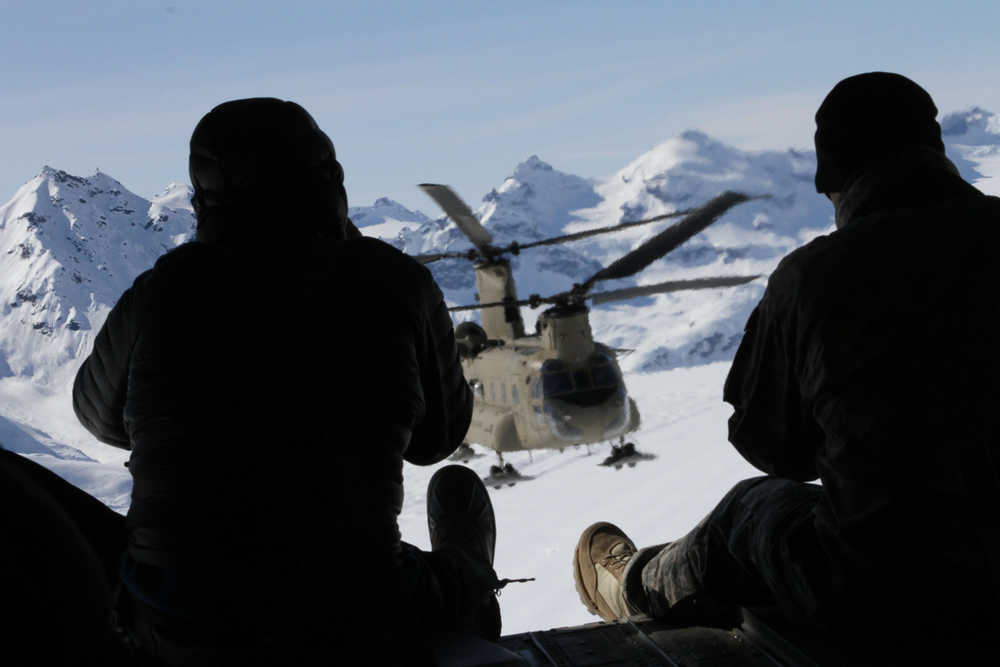 This photo taken Sunday, April 24, 2016, over the Kahiltna Glacier, near Denali in the Alaska Range, shows a Chinook helicopter through the open cargo bay doors of another Chinook. The U.S. Army helped set up base camp on North America's tallest mountain. Three Chinook helicopters the size of city buses took supplies like food, communication equipment and fuel to the base camp at the 7,200-foot level of Denali. (AP Photo/Mark Thiessen)