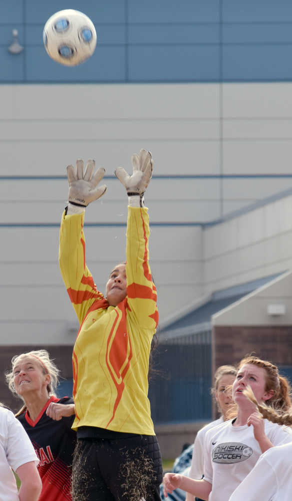 Photo by Jeff Helminiak/Peninsula Clarion Nikiski goalie Brianna Vollertsen stretches for a save Monday at Nikiski High School in front of Kenai Central's Sam Morse and Nikiski's Avery Kornstad.