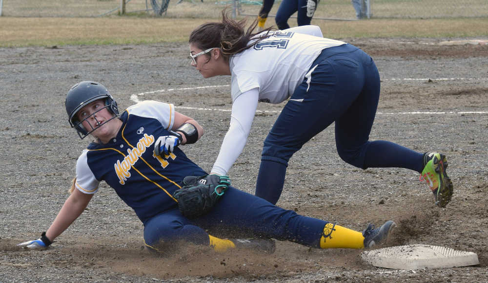 Photo by Jeff Helminiak/Peninsula Clarion Homer's Malina Fellows slides under the tag of Soldotna third baseman Ember Lohrke on Tuesday, May 10, 2016, at the Soldotna Little League fields.