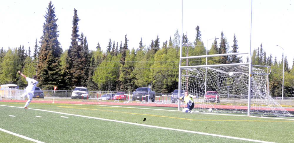 Photo by Dan Balmer/Peninsula Clarion Kenai Central junior defender Max Dye scores a penalty kick goal past SoHi senior goalkeeper Drew Kant in Saturday's boys soccer game at Ed Hollier Field in Kenai. Dye scored three goals in the game, including two PKs to help lead the Kardinals to a 4-1 victory and claim the top seed in the Northern Lights Conference South Division.