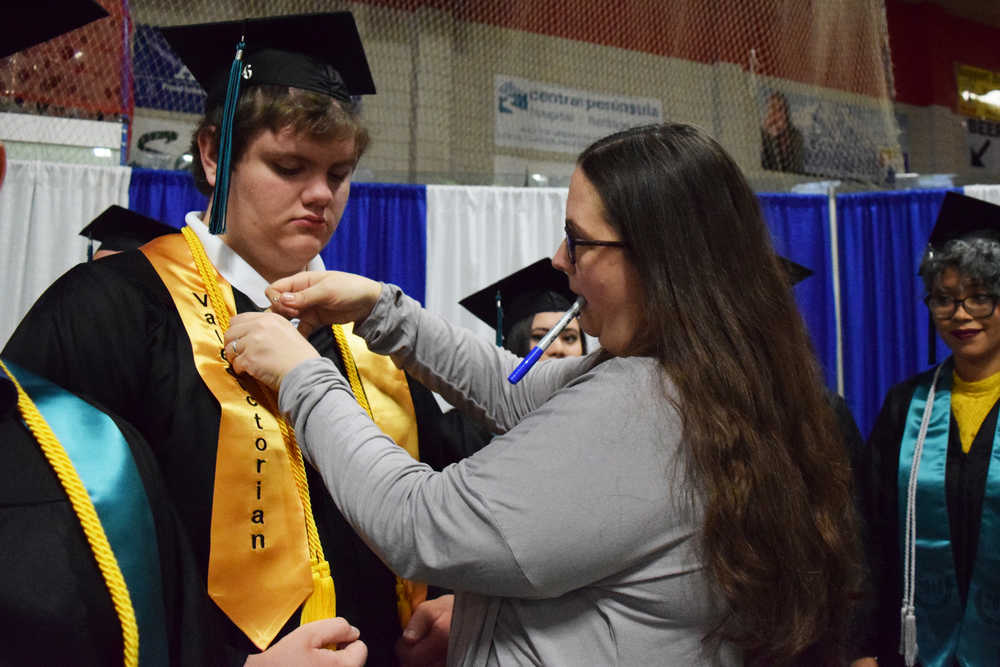 Photo by Megan Pacer/Peninsula Clarion River City Academy Principal Dawn Edwards-Smith helps fasten a stole onto Valedictorian Dakota Edin before the school's graduation ceremony Tuesday, May 17, 2016 at the Soldotna Regional Sports Complex in Soldotna, Alaska.