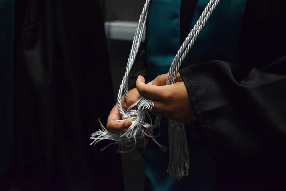 Photo by Megan Pacer/Peninsula Clarion River City Academy senior Marissa Jackson, 18, fidgets with her silver cords moments before walking into her graduation ceremony Tuesday, May 17, 2016 at the Soldotna Regional Sports Complex in Soldotna, Alaska. She joined eight of her peers in an intimate ceremony filled with inside jokes and tearful thank you's.