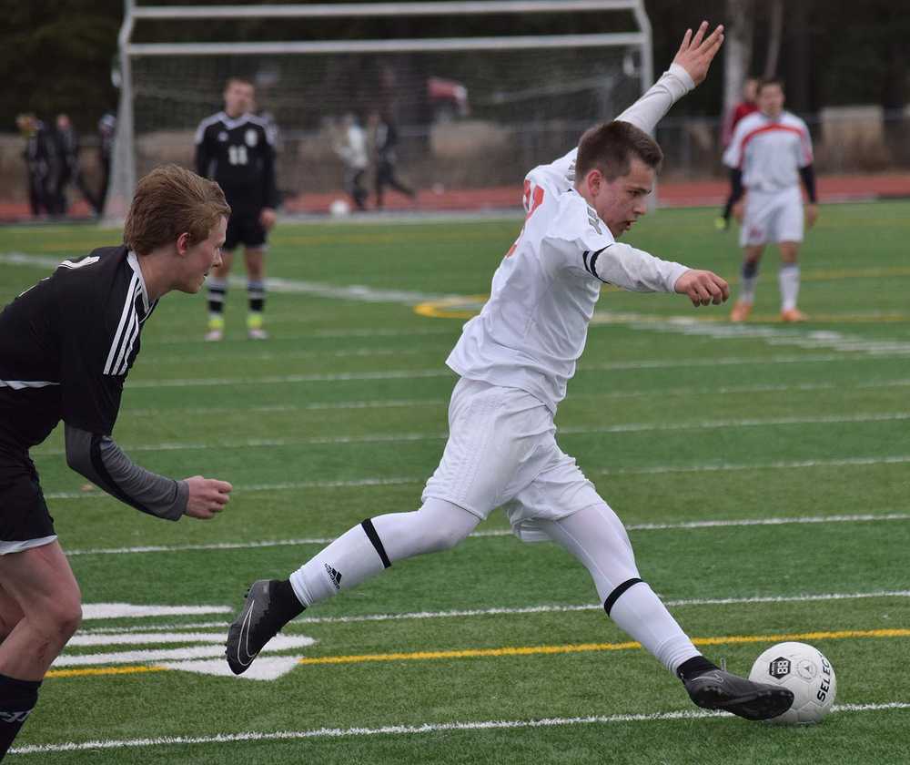 Photo by Joey Klecka/Peninsula Clarion Kenai Central sophomore Zack Tuttle dribbles the ball away from a Nikiski defender April 19 at Ed Hollier Field in Kenai. The Kardinals are hosting the Northern Lights Conference tournament today through Saturday.