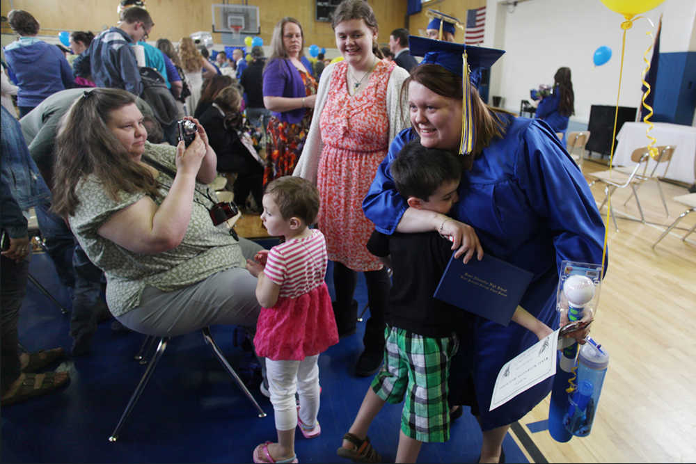 Photo by Kelly Sullivan/ Peninsula Clarion Kenai Alternative graduate Taylor Burke hugs family following the ceremony Wednesday, May 18, 2016, at Kenai Alternative in Kenai, Alaska.