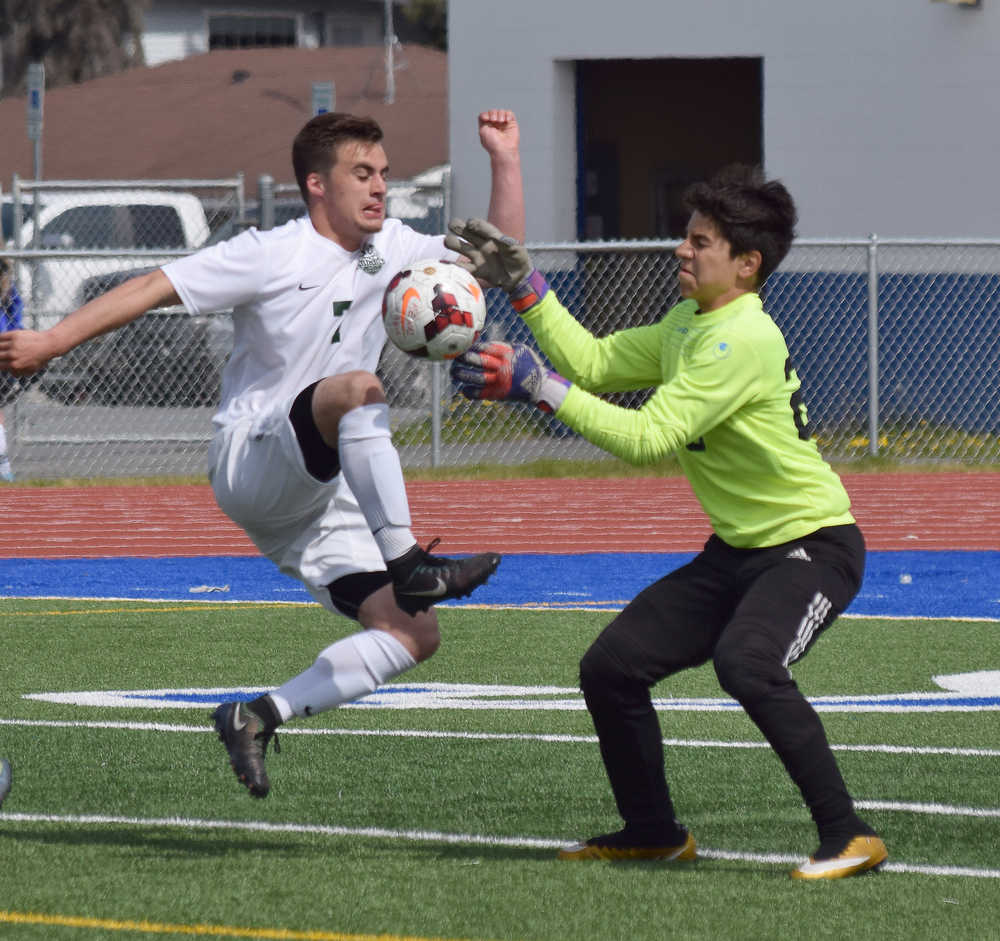 Photo by Joey Klecka/Peninsula Clarion Homer goalkeeper Kenzington Cortez (right) makes a save on the ball against Colony striker Ben Sande in a Northern LIghts Conference tournament quarterfinal Thursday afternoon at Justin Maile Field in Soldotna.