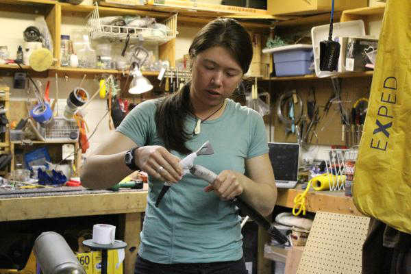Photo by Anna Frost/ Homer News Iris Neary wraps tape around an ice axe she will take with her to Denali. The group modified a lot of their gear, making it lighter or better functioning to their needs.