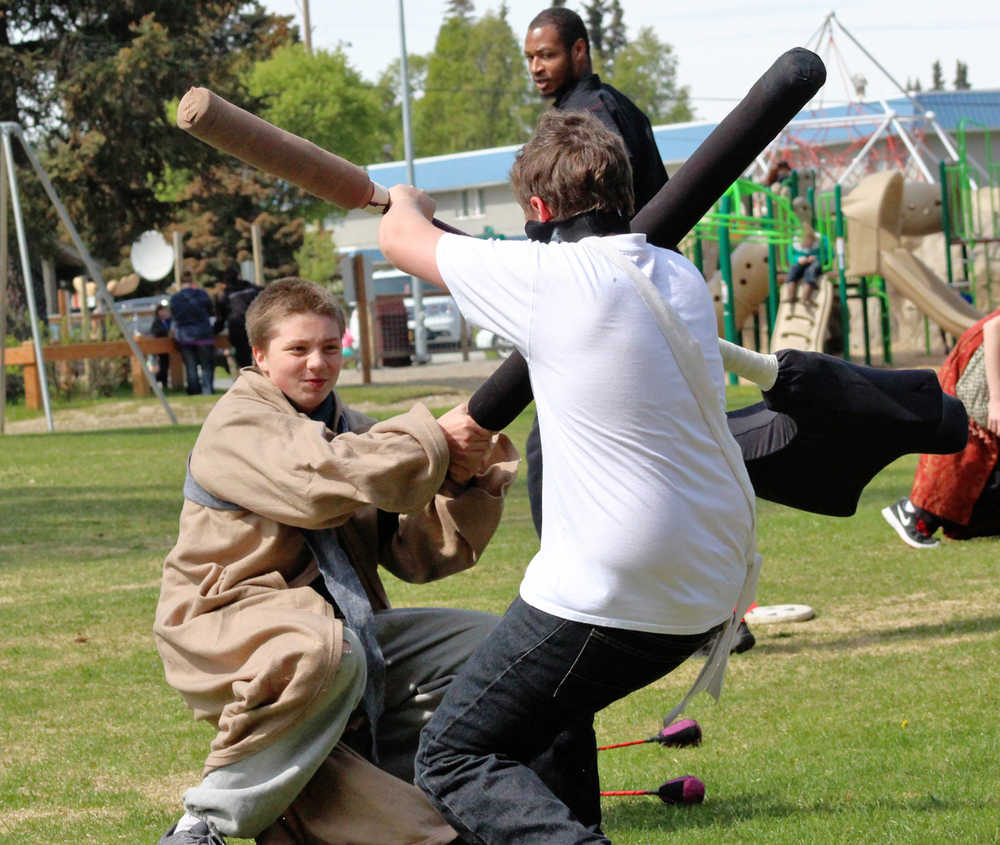 Anthony Kitson (left) fights Jacob Brewington during the Frozen Coast live-action role play group's weekly battle game on Sunday, May 22 in the Kenai Municipal Park.