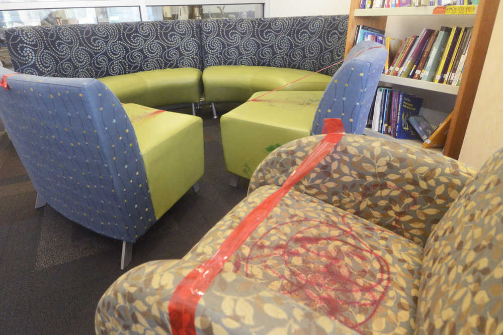 Photo by Megan Pacer/Peninsula Clarion Red tape prevents people from sitting on several pieces of vandalized furniture Wednesday, May 25, 2016 at the Kenai Community Library in Kenai, Alaska. Several chairs and a stool were destroyed with a paint-like substance, and a couch was slashed with a knife at the library last week.