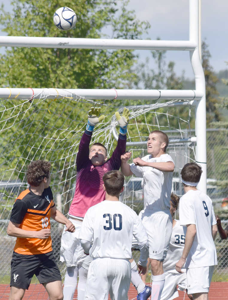 Photo by Joey Klecka/Peninsula Clarion Soldotna goalkeeper Blake Jones and teammate Timmy Smithwick rise up to meet a corner kick by West Anchorage at the ASAA state soccer tournament Thursday at Eagle River High School.
