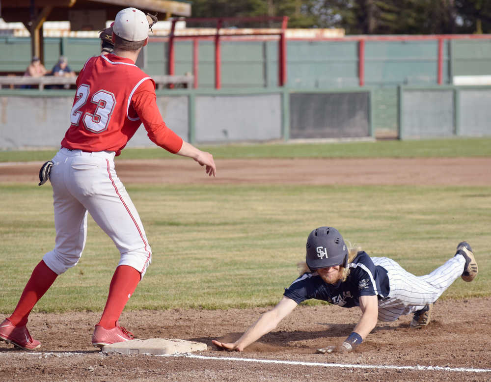 Photo by Jeff Helminiak/Peninsula Clarion Soldotna's Kenny Griffin dives back to first base ahead of the tag of Ben Werner on Friday in the Southcentral Conference championship at Coral Seymour Memorial Park in Kenai.