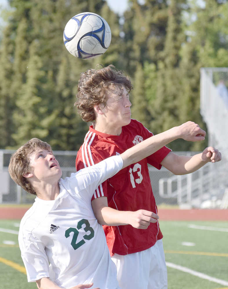 Photo by Joey Klecka/Peninsula Clarion Kenai Central freshman Damien Redder (13) heads the ball with Service sophomore Dorian Cornichuck in Friday's state soccer semifinal contest at Service High School.