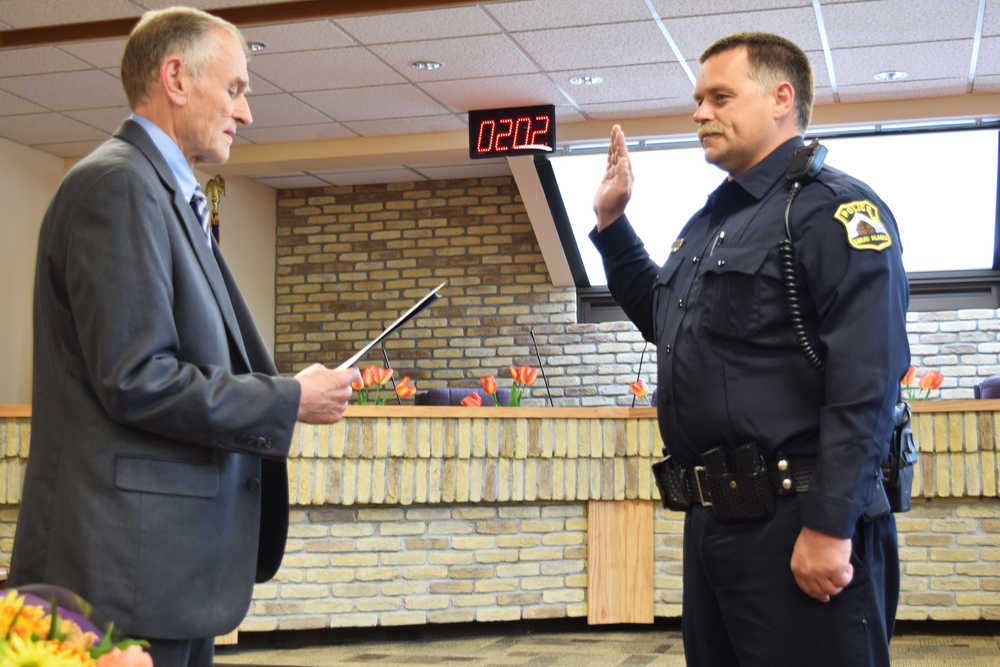 Photo by Megan Pacer/Peninsula Clarion Attendees at a swearing in ceremony for Kenai's new police chief, David Ross, enjoyed a cake made in his honor Tuesday, May 31, 2016 at Kenai City Hall in Kenai, Alaska. Ross takes over for former Kenai Police Chief Gus Sandahl, who announced his retirement from law enforcement in early May.