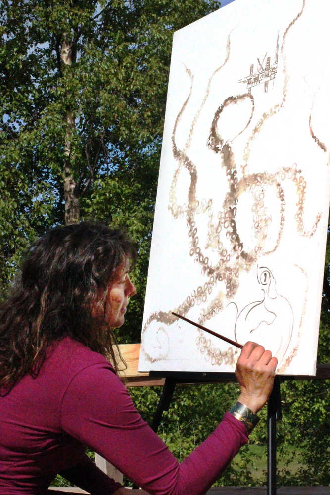 Louise Nutter works on an octopus-ink painting on Wednesday, June 1 at her home in Nikiski. The tentacles are printed from those of an octopus Nutter captured in a shrimp trap in Prince William Sound.