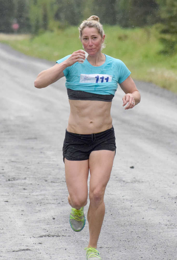 Photo by Joey Klecka/Peninsula Clarion Women's 5K race winner LeeAnn Burns of Eagle River takes a quick drink midway through Saturday's Run for the River in Soldotna.