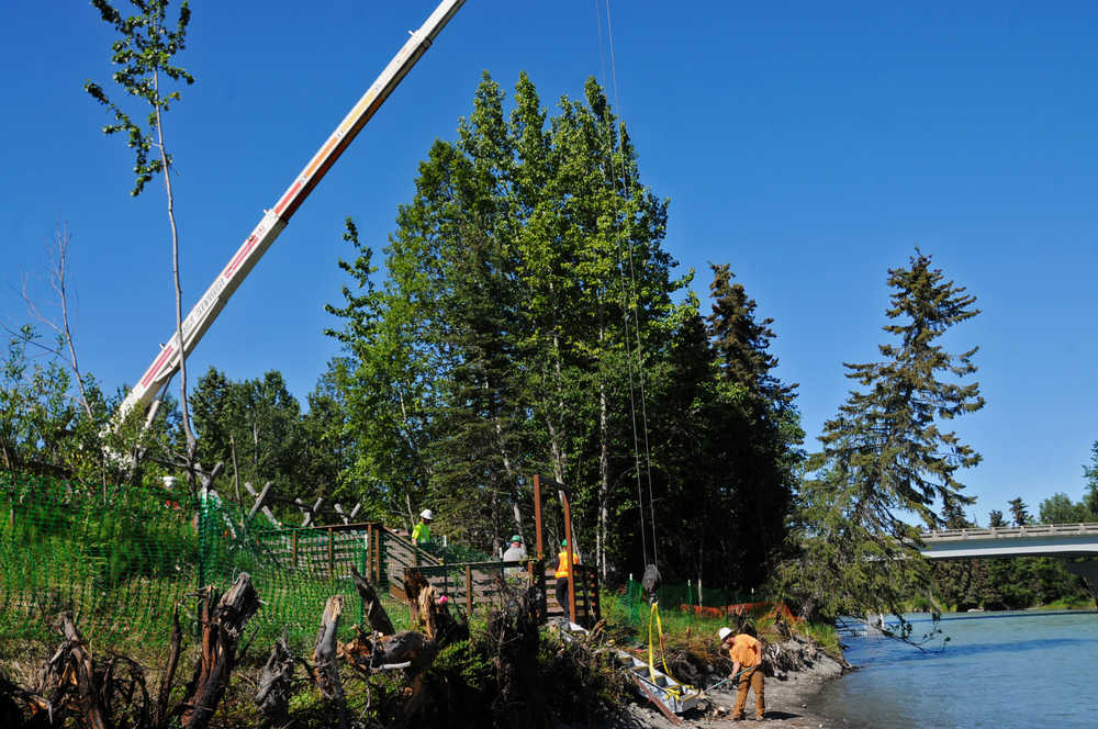 Photo by Elizabeth Earl/Peninsula Clarion Construction workers put the finishing touches on a new walkway being installed near the boat launch on the Kasilof River in Kasilof, Alaska on Wednesday, June 15, 2016. The new walkway will provide access for pedestrians over the riverbank down from the paved path along the access road.