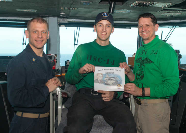 PHILIPPINE SEA (June 13, 2016) - Seaman Zachary Hale, from Soldotna, Alaska, assigned to the Chargers of Helicopter Sea Combat Squadron (HSC) 14 receives the Sailor of the Day award from Capt. Greg Huffman, USS John C. Stennis' (CVN 74) commanding officer, and Command Master Chief Trenton Schmidt. Providing a ready force supporting security and stability in the Indo-Asia-Pacific, John C. Stennis is operating as part of the Great Green Fleet on a regularly scheduled 7th Fleet deployment. (U.S. Navy photo by Mass Communication Specialist 2nd Class DeAndrae McDaniel/ Released)