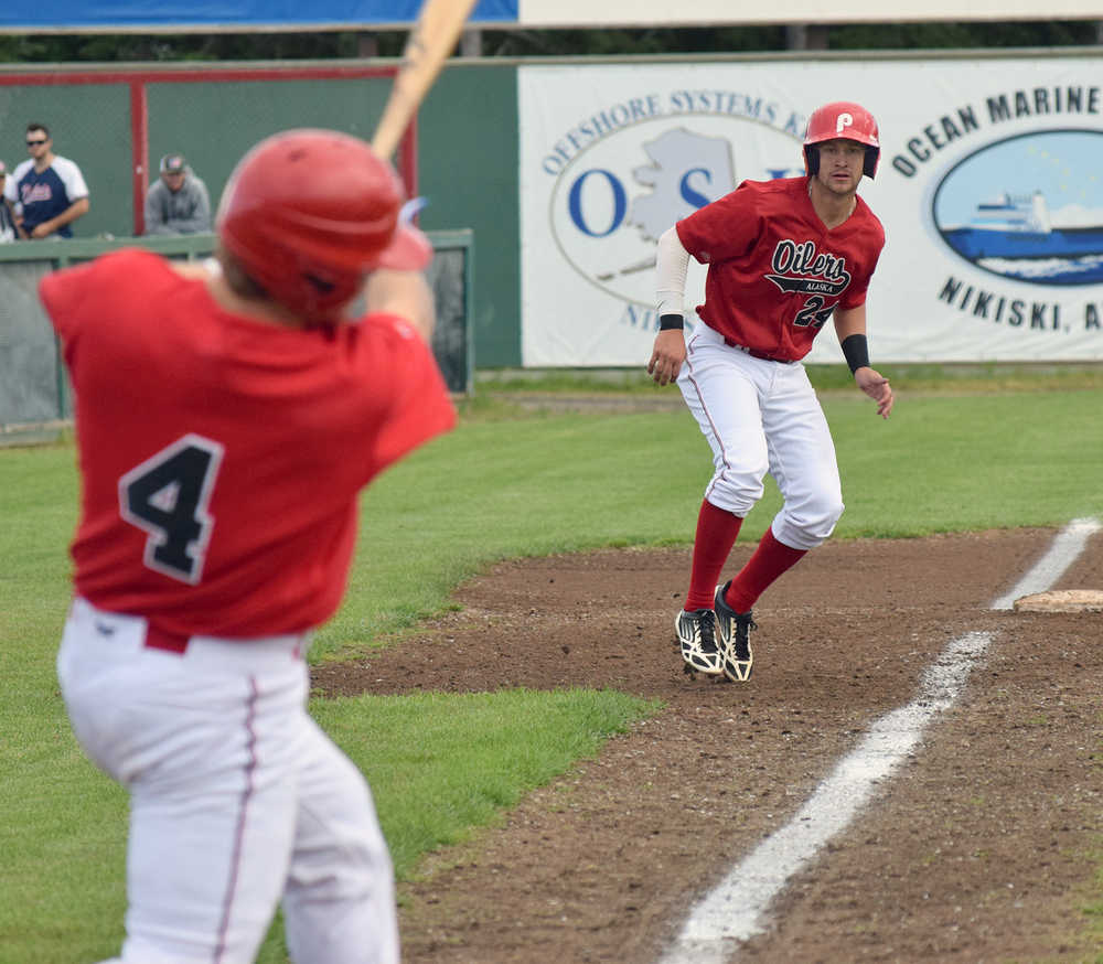 Photo by Joey Klecka/Peninsula Clarion Jonathan Washam (4) hits a grounder up the middle as teammate Trey Dawson makes his move from third base Tuesday evening at Coral Seymour Memorial Park in Kenai.