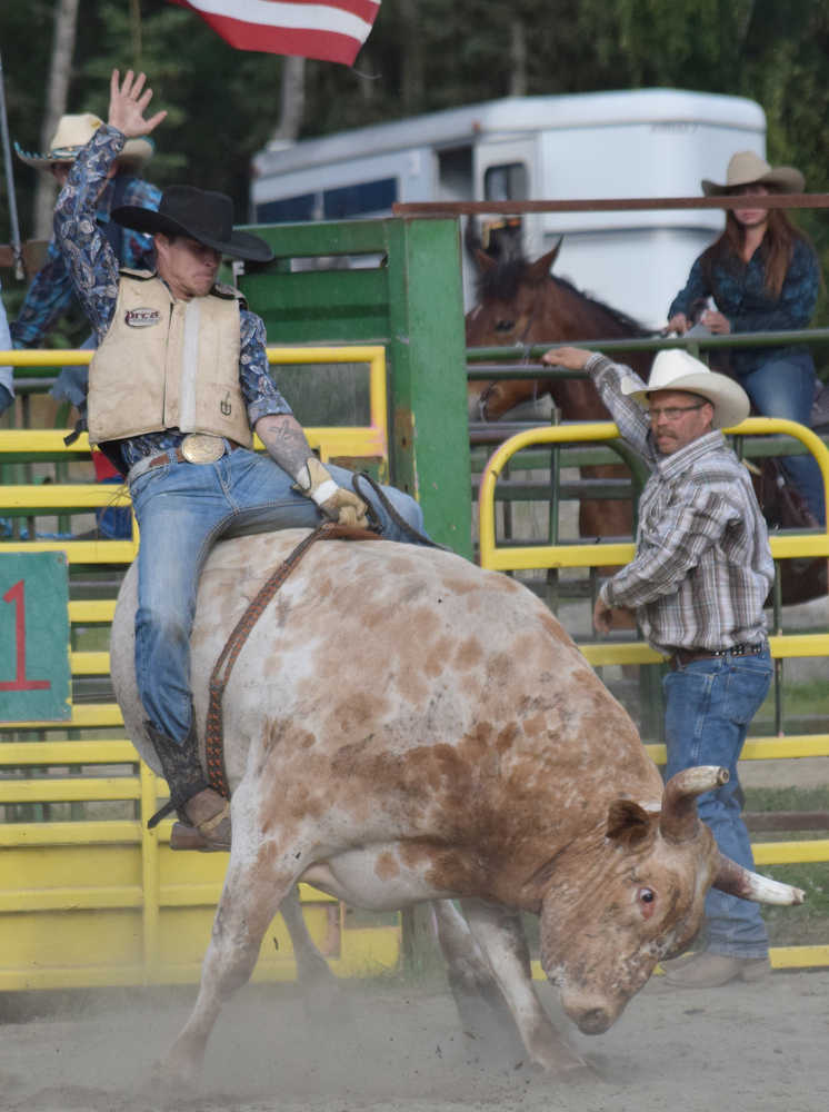 Photo by Joey Klecka/Peninsula Clarion Warren Simpson holds tight as he rides his bull June 25 at the Rodeo Alaska Tour stop at the Soldotna rodeo grounds.