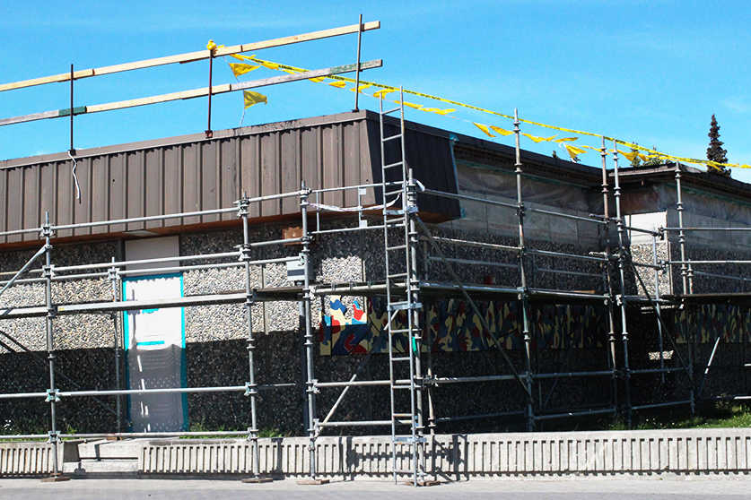 Ben Boettger/Peninsula Clarion Scaffolding surrounds the fascade of Kenai Middle School during its summer-long asbestos removal treatment on Thursday, June 30 in Kenai. Asbestos fire-proofing material is being taken from its roof beams and disposed of in the Kenai Peninsula Borough landfill.
