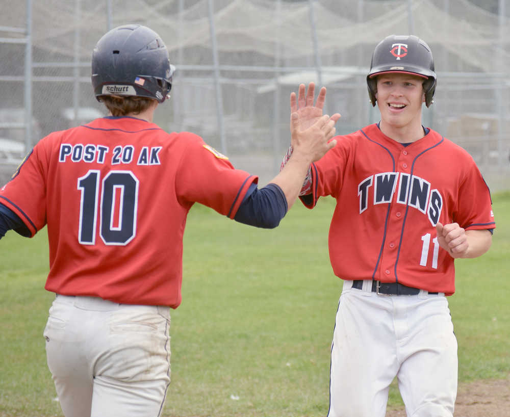 Photo by Joey Klecka/Peninsula Clarion Paul Steffensen (11) gets a high-five from Post 20 Twins teammate Josh Darrow Saturday against South Post 4 at the Kenai Little League fields.