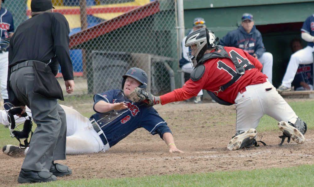 Photo by Jeff Helminiak/Peninsula Clarion Peninsula Oilers catcher Jordan Frese tags out Aaron Shackelford of the Chugiak Chinooks at home plate in the sixth inning Sunday at Coral Seymour Memorial Park in Kenai to keep the score locked at 2-2.