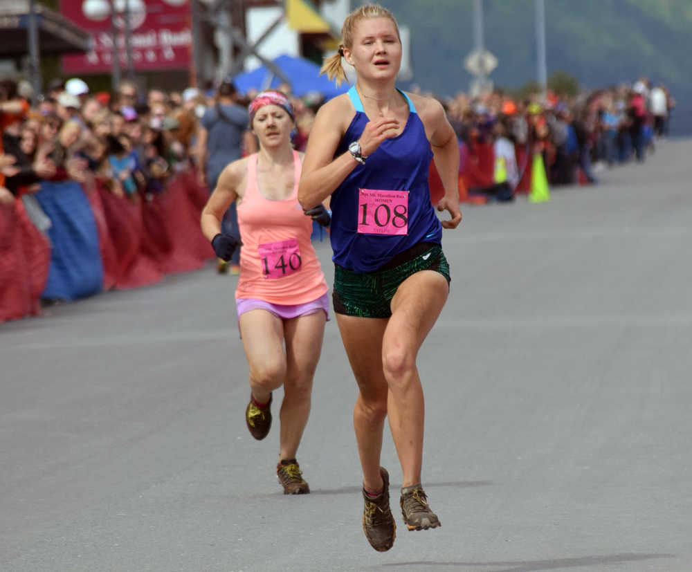 Photo by Jeff Helminiak/Peninsula Clarion Soldotna's Taylor Ostrander passes Anchorage's April McAnly for ninth place near the finish of the women's Mount Marathon race Monday in Seward.