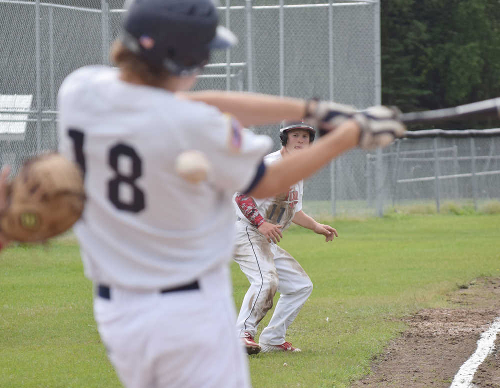 Photo by Joey Klecka/Peninsula Clarion Joey Becher (18) takes a swing at an East Anchorage pitch while Post 20 Twins teammate Paul Steffensen looks on Wednesday afternoon at the Bill Miller Big Fish Wood Bat tournament at the Kenai Little League Fields.