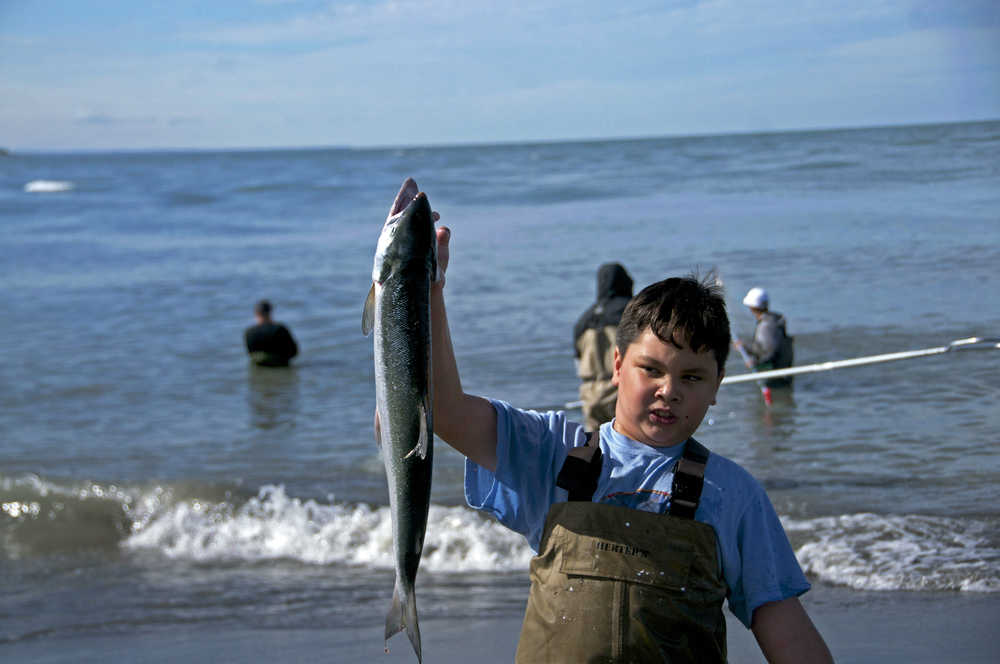 Photo by Elizabeth Earl/Peninsula Clarion Victor Mallari, 10, proudly displays the sockeye salmon his father caught in his dipnet at the Kenai beach in Kenai, Alaska, on Sunday, July 10, 2016. The popular Kenai River personal use dipnet fishery opened Sunday morning at 6 a.m. and will be open until July 31.