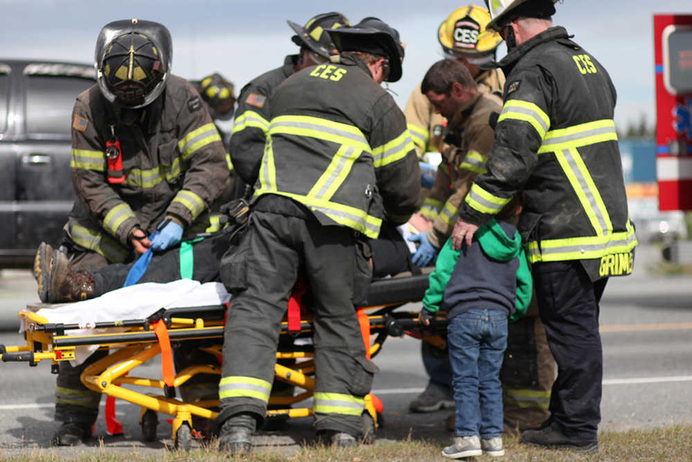 Central Emergency Services responders prepare to transport an injured person from the scene of a two-vehicle accident Wednesday, July 13, 2016, on Kalifornsky Beach Road in Soldotna, Alaska.