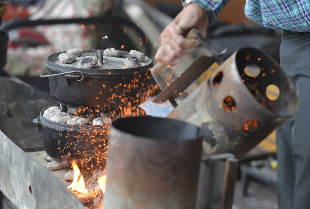 Photo by Kelly Sullivan/ Peninsula Clarion Nels Anderson pours out ready-to-go coals Thursday, July 16, 2015, in Soldotna, Alaska.