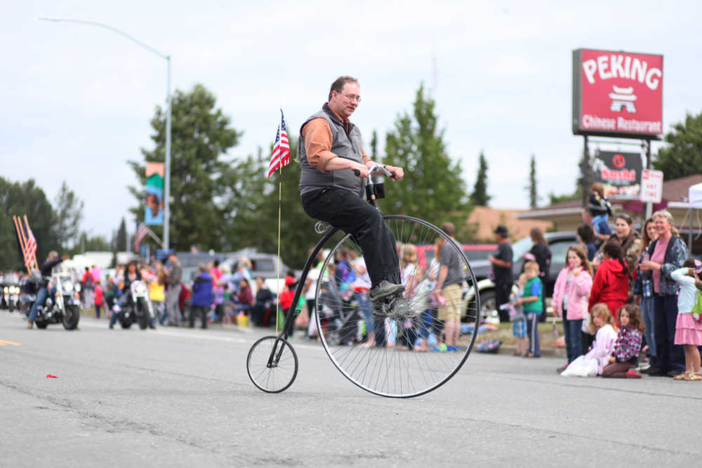 Photo by Kelly Sullivan/ Peninsula Clarion Doug Field rode his Penny-Farthing during Kenai's July 4th Parade on Monday, July 4, 2016 in Kenai, Alaska.