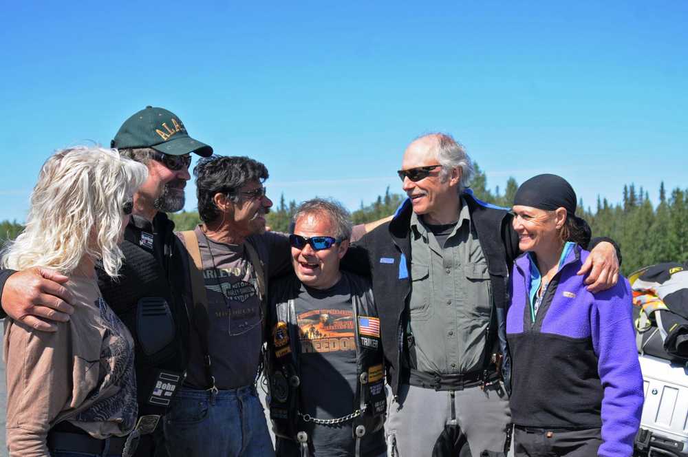 Photo by Elizabeth Earl/Peninsula Clarion Friends gather at the Harley-Davidson store outside Soldotna, Alaska, on Friday, July 15, 2015, to farewell Randy McKinney (second from right) and Lana McKinney (far right) as the couple departs on a multi-year motorcycle trip around the world. The Ninilchik couple plans to ride through 86 countries, treating children with dysentery as they go.