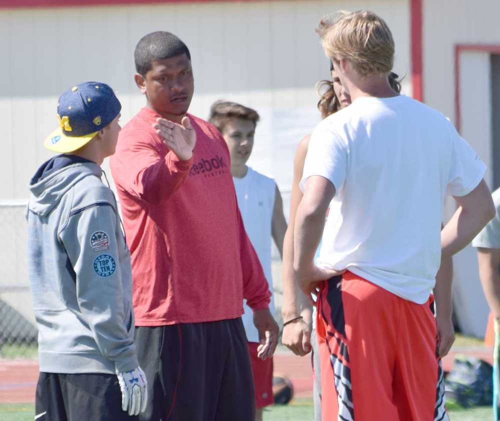 Photo by Jeff Helminiak/Peninsula Clarion Ex-NFL player Juaquin Iglesias instructs players during the passing portion of the Alaska All Star Football Camp at Kenai Central High School on Friday.