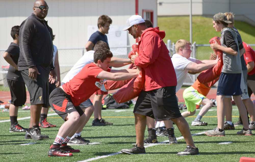 Photo by Jeff Helminiak/Peninsula Clarion Kenai Central's Matthew Zorbas practices blocking with ex-NFL player Tony Casillas at the Alaska All Star Football Camp on Friday at Kenai Central High School. In the background observing the drill is ex-NFL player Flozell Adams.