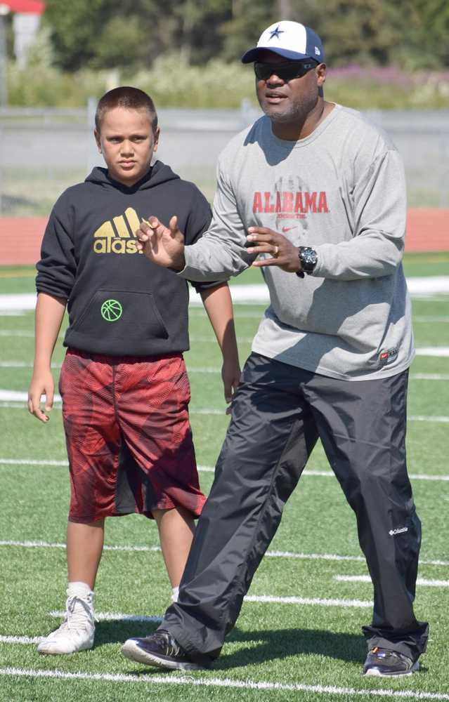 Photo by Jeff Helminiak/Peninsula Clarion Benni Collins of Eagle River listens as ex-NFL player George Teague instructs him on secondary play Friday at the Alaska All Star Football Camp at Kenai Central High School.